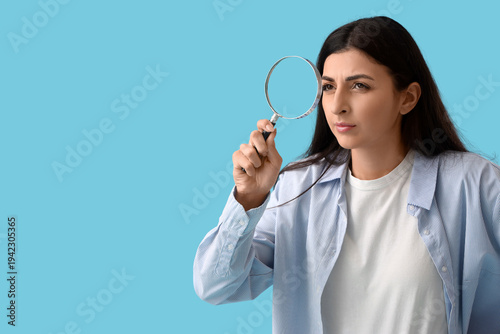 Young woman with magnifier ...
