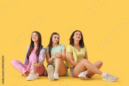 Happy teenage girls sitting...