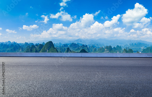 Empty asphalt highway and karst mountain landscape under a blue sky in Guilin, China.
