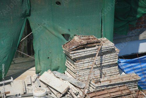 Steel reinforcement bars and construction materials placed on a concrete floor at a building construction site.