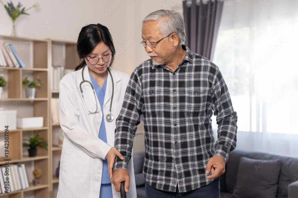 Obraz premium Senior man practicing walking with cane assisted by female healthcare professional during home rehabilitation session in modern living room, elderly care, physical therapy and recovery.