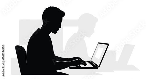 Focused silhouette of a young man typing on a laptop in a modern workspace