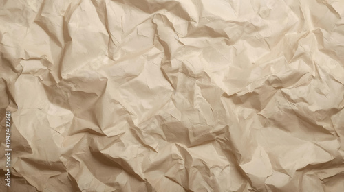 Close-up view of a crumpled light brown paper texture with many wrinkles and folds, creating an abstract background.