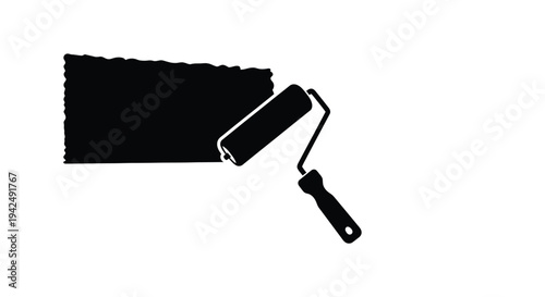 Paint roller applying black paint creating a textured surface silhouette