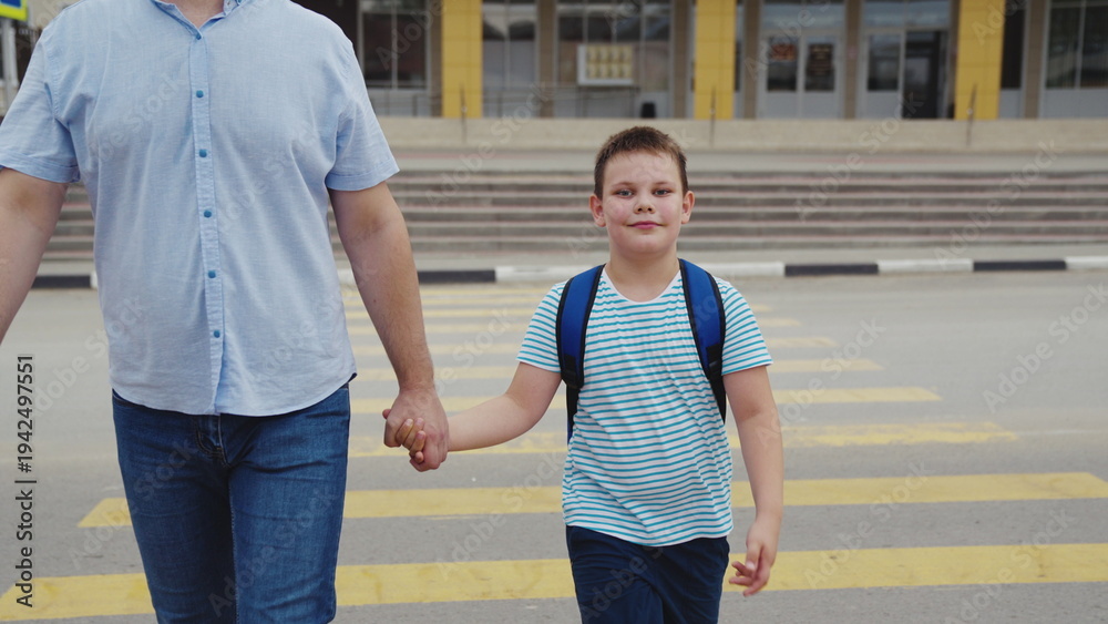 Fototapeta premium Family walks to school are the best, Child with a backpack ready for the day, Loving dad by his son’s side, Every school day is special, Boy’s smile before he learns, Growing up with daily walks