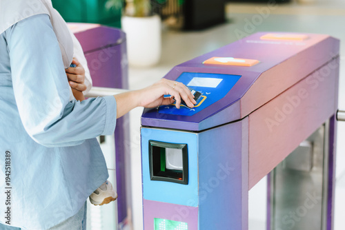 Obraz na plátně Muslim woman using a contactless credit card to pass through an automated public
