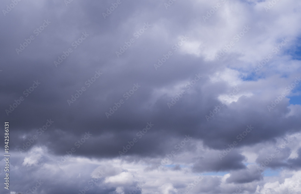 Fototapeta premium Natural blue sky with moving white and grey clouds creating dramatic cloudscape texture suitable for weather background.