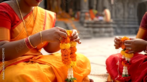 Indian women making flower garlands.
