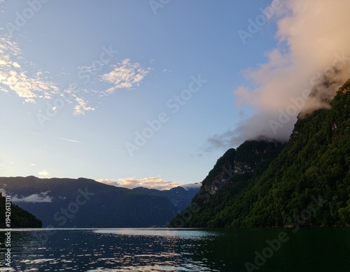 Serene Fiordland Landscape with Misty Mountains and Calm Water at Dawn.