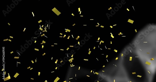 Falling metallic gold confetti pieces glinting on dark stage backdrop, with rising gray smoke plume