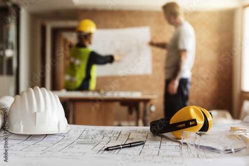 Εκτύπωση καμβά Construction site with two workers reviewing blueprints