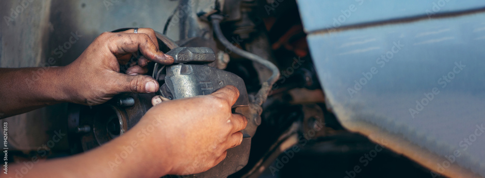 Obraz premium Banner Mechanic man hands repairing car shop. Man hands fixing Car machinery vehicle mechanical service. Panorama open vehicle hood checking up auto mobile. Car maintenance engineer with copy sapce
