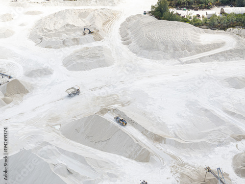 Aerial view of stark white mounds of limestone dominate the landscape, carved by heavy machinery under the bright Florida sun, Miami, Florida, United States.