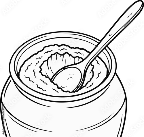 A spoon rests in a jar filled with a creamy, textured substance