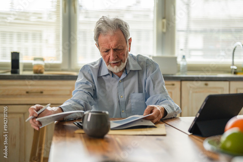Senior man analyzing financial documents and managing budget
