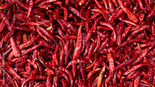Top view of vibrant dried red chili peppers spread out to dry in the sun. Sun dried spicy Thai chilies texture an essential ingredient in Asian cuisine and traditional food preservation.