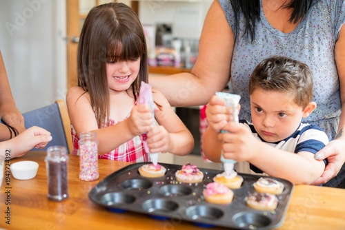 Принти на полотні Children decorating cupcakes with icing and sprinkles