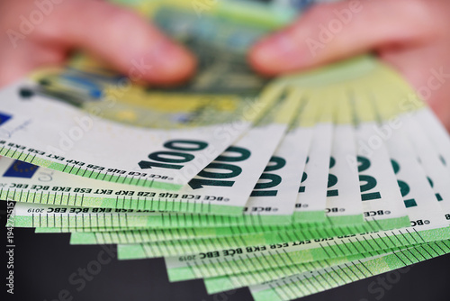 Bargeld, zwei Hände halten 100 Euro Banknoten.