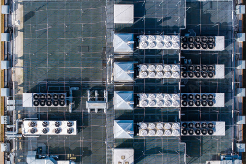 Aerial view of a large data center building rooftop presenting extensive hvac systems and ventilation units managing temperature, Warsaw, Masovian Voivodeship, Poland.