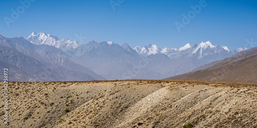 Scenic landscape view of snowcapped Hindu Kush mountain range peaks seen from high-altitude desert, Ishkashim, Gorno-Badakhshan, Tajikistan Pamir