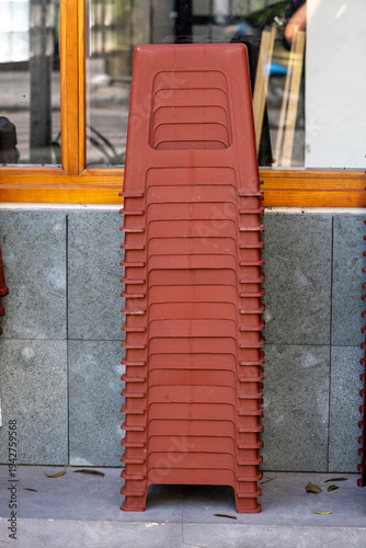 Bilde på lerret A stack of terracotta-coloured plastic chairs neatly arranged outdoors in Hanoi,