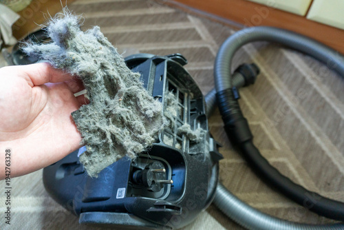 A dirty vacuum cleaner filter clogged with dust and hair. Concept of cleaning and allergies.