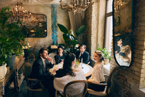 Bilde på lerret Group in mid century evening wear gathered around round cafe table