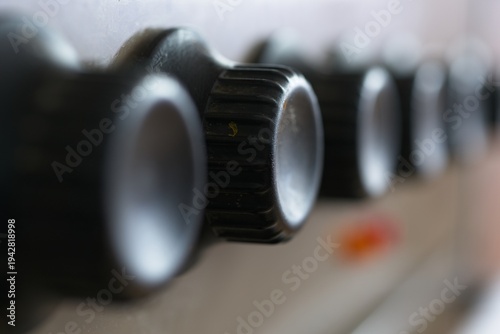 Metal door handle on wooden door close up, bellow handle there is keyhole with key out of focus