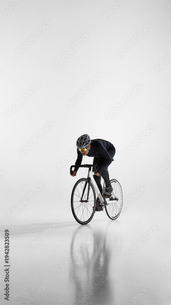 Naklejka premium Professional cyclist riding fast on road bike isolated on white. Concept of high speed performance, competitive cycling, athletic power, and sport motivation.