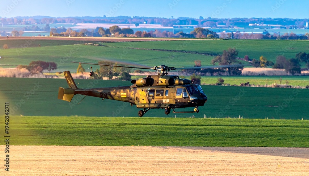 Fototapeta premium Military helicopter over rural fields