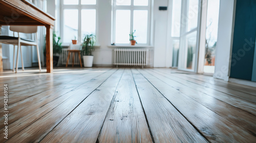 Wooden floorboards creating a textured surface in a bright, uncluttered room with plants and windows, ideal for design elements