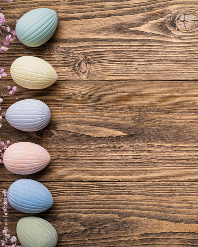 Vertical Easter background, pastel eggs, flowers, rustic wooden table poster