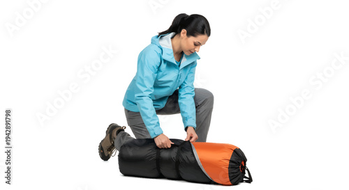 Woman preparing orange and black sleeping bag for outdoor adventure