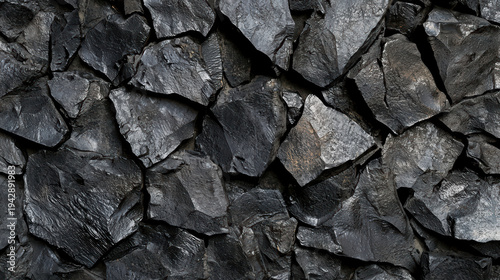 The dark, rough texture of fractured obsidian rocks creates an elegant and natural backdrop, showcasing a striking contrast of shadows and light on the edges.