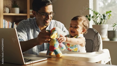 smiling indian father working remotely on laptop at table while watching baby in high chair. work life balance concept. family lifestyle
