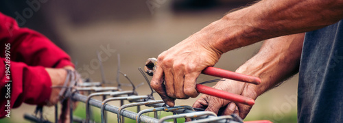 Obraz na plátně Banner Construction Worker hands using pincer pliers iron wire