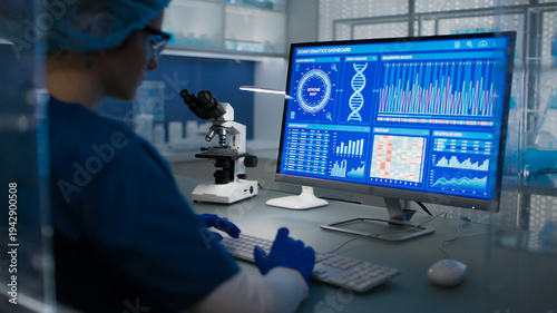 Female scientist in protective clothes and glasses looking at the computer screen. Researching diseases and DNA test results