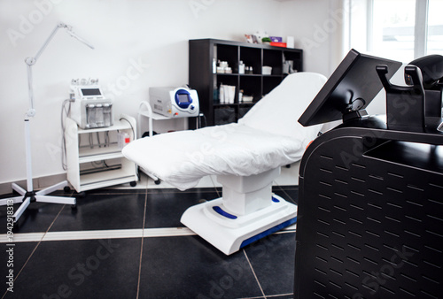 Medical treatment room featuring a white examination table, modern equipment, and organized storage, creating a clean and professional healthcare environment for patient care