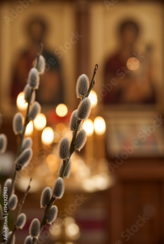 Spring willow branches in focus with blurred church candles. Religious Orthodox Palm Sunday concept