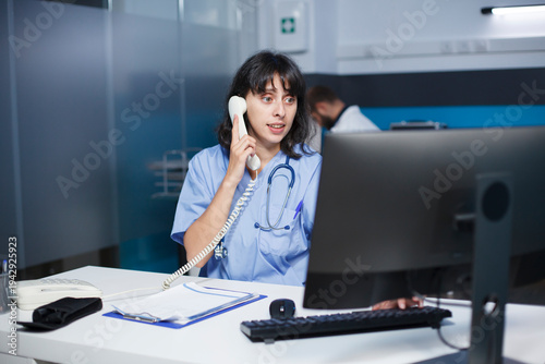 Fényképezés In the hospital office, a medical practitioner answers phones and schedules appointments