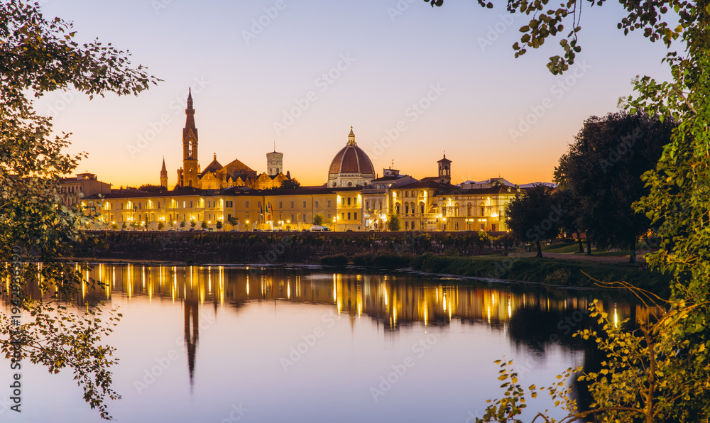 Obraz premium Florence skyline reflecting on Arno River during sunset, iconic Duomo and Ponte Vecchio illuminating historical cityscape