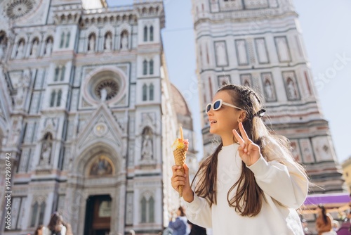 Fotografie Girl enjoying gelato in Florence, making peace sign with Duomo and Campanile di