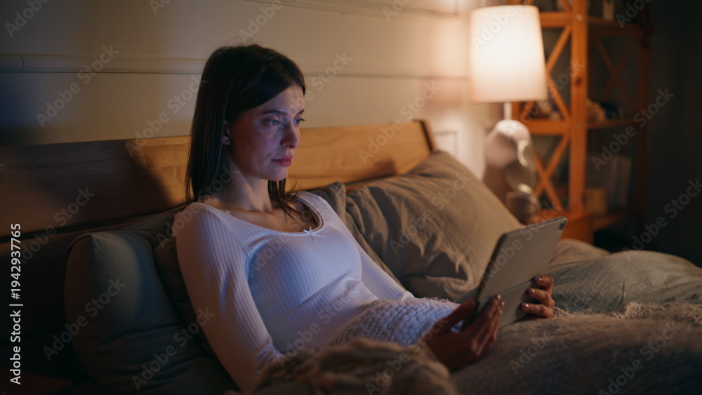 Obraz premium Relaxed woman looking tablet lying bed closeup. Brunette watching online content