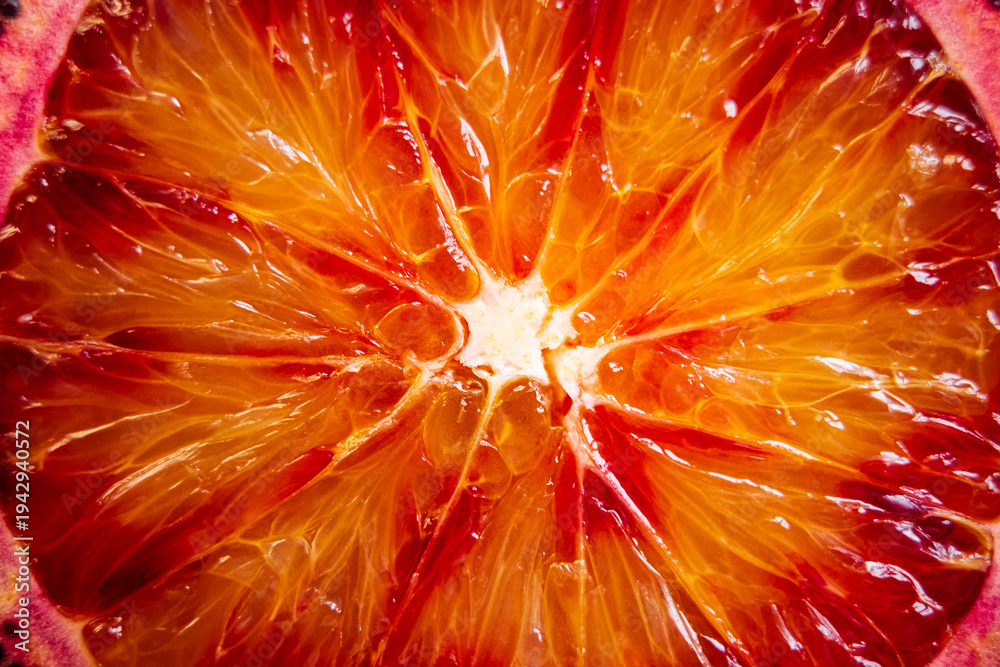 Fototapeta premium Vibrant orange zest reveals intricate patterns of a blood orange cut in half