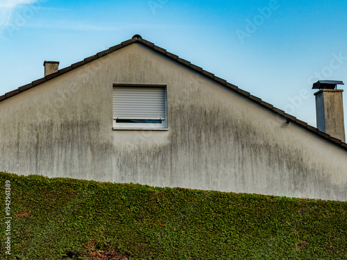 Feuchte und verschmutzte Wetterseite eines Hauses