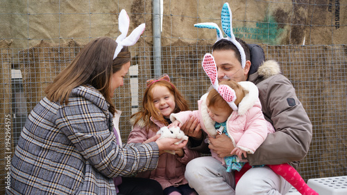 Fotografia Family enjoying easter celebration with baby rabbits at farm