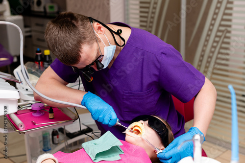 Dental professional focused on patient care during an afternoon procedure in a modern clinic with advanced equipment and comforting atmosphere