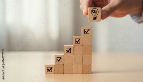 Business Innovation and Performance Strategy. Hand placing idea lightbulb block above rising checklist cube steps, representing strategic planning, performance improvement, and measurable progress.
