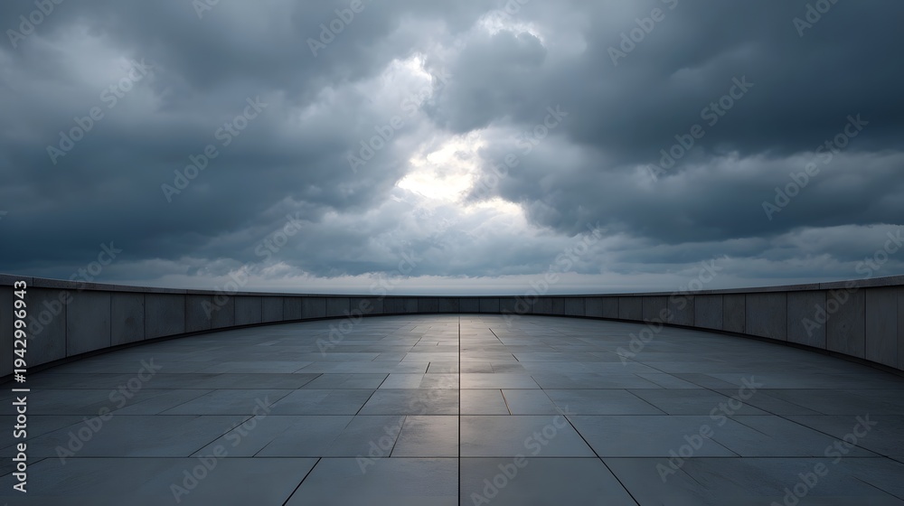 Naklejka premium A curved modern terrace paved with large tiles overlooking a calm horizon under a dramatic luminous cloudy sky