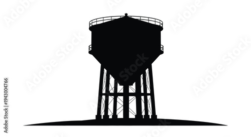 A stark black water tower against a bright backdrop silhouette